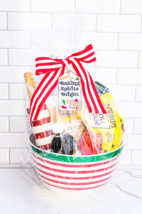This is one of the free Christmas treat gift tags you can download in this post. It says, Baking Spirits Bright featuring Christmas cookies and baking supplies. It is attached to a gift basket filled with Christmas baking supplies, a Christmas red and white stripped rolling pin, and a red and green spatula.
