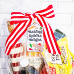 This is one of the free Christmas treat gift tags you can download in this post. It says, Baking Spirits Bright featuring Christmas cookies and baking supplies. It is attached to a gift basket filled with Christmas baking supplies, a Christmas red and white stripped rolling pin, and a red and green spatula.