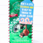 This is one of the free Christmas treat gift tags you can download in this post. It says, Here’s a Little Encourage-Mint. At the bottom it has some candy canes and peppermints. The tag is attached to a bag of Lindt Mint Cookie chocolates.