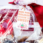 This is one of the free Christmas treat gift tags you can download in this post. It says, Hope Your Holiday Season is Sweet. This fag features a gingerbread man and other sweet Christmas treats. The tag is attached to a gift basket filled with holiday treats.