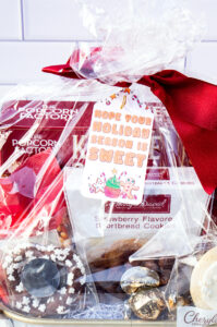 This is one of the free Christmas treat gift tags you can download in this post. It says, Hope Your Holiday Season is Sweet. This fag features a gingerbread man and other sweet Christmas treats. The tag is attached to a gift basket filled with holiday treats.
