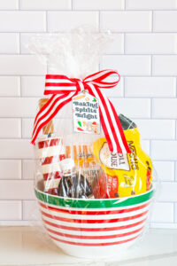  This is one of the free Christmas treat gift tags you can download in this post. It says, Baking Spirits Bright featuring Christmas cookies and baking supplies. It is attached to a gift basket filled with Christmas baking supplies, a Christmas red and white stripped rolling pin, and a red and green spatula.