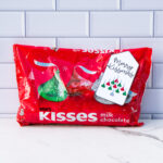 This is one of the free Christmas treat gift tags you can download in this post. It says, Merry Kissmas and featuring Hershey Kisses in their iconic Christmas design in the shape of a bell. The tag is attached to a bag of Hershey kisses.