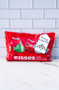 This is one of the free Christmas treat gift tags you can download in this post. It says, Merry Kissmas and featuring Hershey Kisses in their iconic Christmas design in the shape of a bell. The tag is attached to a bag of Hershey kisses.