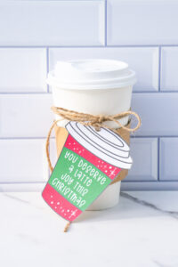 This is one of the free Christmas treat gift tags you can download in this post. It says, You Deserve a Latte Joy this Christmas. It is on a hand drawn coffee cup tag that is red with snowflakes. The tag is attached to a to go cup of coffee.