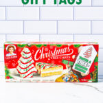 At the top it says free Christmas gift tags. At the bottom it says 15 unique designs. In-between, the image is of one of the free Christmas treat gift tags you can download in this post. It says, You’re a Tremendous Teacher. This version of the tag features the Little Debbie Christmas cake. The tag is attached to a box of Little Debbie Cakes.