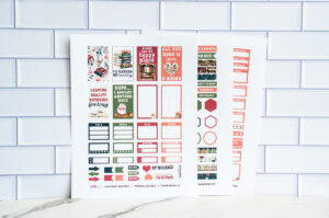 Three printed sheets of book-themed planner stickers displayed against a white subway-tile background, featuring reading quotes, labels, and decorative elements.
