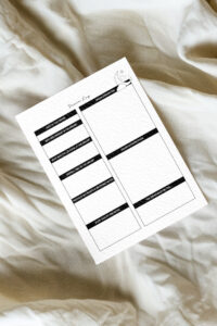 Dream log printable placed on soft, cream-colored fabric, showing clean black-and-white sections for dream details, interpretation, and notes.