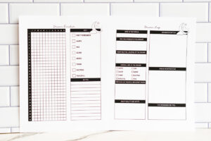 Side-by-side printed dream tracker and dream log pages on a white tiled wall, highlighting the grid-style dream tracker and categorized prompts on the dream log sheet.