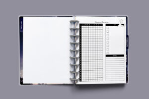 Printed dream tracker page inside a discbound planner, shown on the right-hand side with the monthly grid, key checkboxes, and lined notes section.