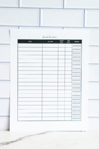 Side-by-side view of two printable book tracker pages with title, author, start date, end date, and star rating columns, laid out on a white tile backdrop.