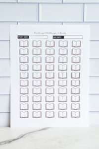A printable &ldquo;Reading Challenge: 50 Books&rdquo; page featuring 50 blank open-book icons arranged in rows, with start and end date fields at the top.