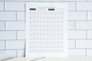 A printable &ldquo;Reading Challenge: 100 Books&rdquo; sheet displaying 100 outlined closed-book icons in diagonal rows, with start and end date fields at the top.