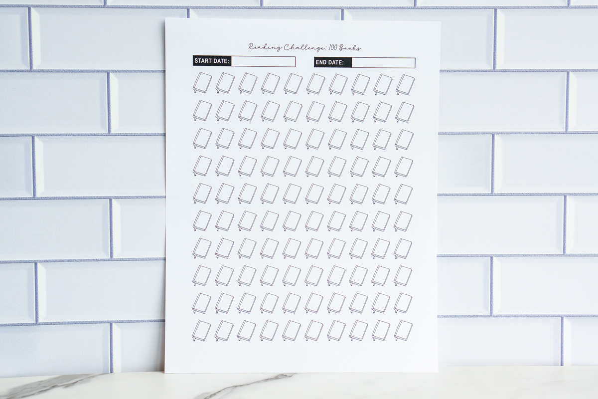 A printable “Reading Challenge: 100 Books” sheet displaying 100 outlined closed-book icons in diagonal rows, with start and end date fields at the top.