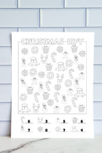 Black and white Christmas I-Spy answer key showing holiday icons such as candy canes, reindeer, gingerbread men, wreaths, presents, snowflakes, snowmen, and cars with trees on top. Correct counts are filled in beneath each icon.