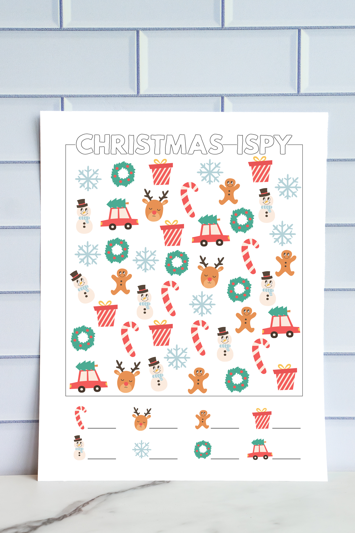 Printed full-color easy Christmas I-Spy worksheet featuring large, simple holiday icons including reindeer, wreaths, gingerbread men, presents, snowflakes, snowmen, candy canes, and cars with Christmas trees. Blank lines at the bottom for kids to record their counts.