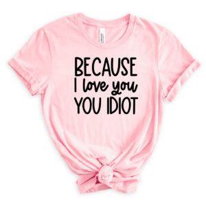 Light pink T-shirt with the quote &ldquo;Because I love you, you idiot&rdquo; printed in bold black text.