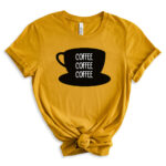 Mustard yellow T-shirt featuring a large black coffee cup graphic with the words “Coffee Coffee Coffee” stacked inside.