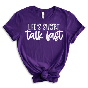 Purple short-sleeve t-shirt with the phrase &ldquo;Life&rsquo;s Short, Talk Fast&rdquo; in bold white lettering, styled with rolled sleeves and a front knot.