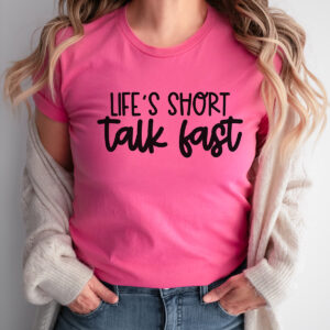 Woman wearing a bright pink T-shirt that says &ldquo;Life&rsquo;s short, talk fast&rdquo; in bold black lettering.