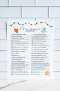Full Christmas bucket list printable with festive illustrations shown against a white tile background, featuring a two-column checklist of holiday activities.