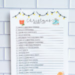 Christmas bucket list printable featuring illustrated string lights, hot cocoa, and ice skates, photographed upright against a tile background.