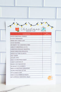 Christmas bucket list printable with a red &lsquo;Experience / Date Completed&rsquo; header section, festive illustrations, and a checklist of holiday activities.