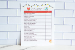Full-page Christmas bucket list printable with an &lsquo;Experience / Date Completed&rsquo; layout, displayed on a tile wall background.