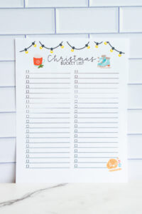 Blank customizable Christmas bucket list printable with two columns of empty checkboxes, hanging Christmas lights, hot cocoa, and ice skates illustrations.