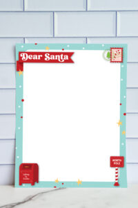 Blank Dear Santa letter printable with turquoise border, decorative banner title, and holiday icons including a mailbox, North Pole sign, and postage stamp design.