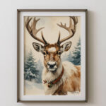 Framed vintage-style watercolor reindeer print displayed on a plain wall, featuring a reindeer with large antlers in a snowy forest.
