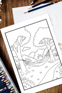 Relaxation coloring page of a peaceful hammock tied between two trees in a quiet forest setting, shown on a wooden table with colored pencils nearby.