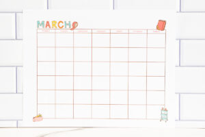 March craft-themed undated calendar page on a white subway while backdrop with a marble countertop.