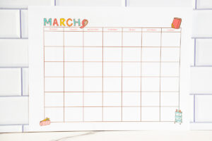 March craft-themed undated calendar page on a white subway while backdrop with a marble countertop.