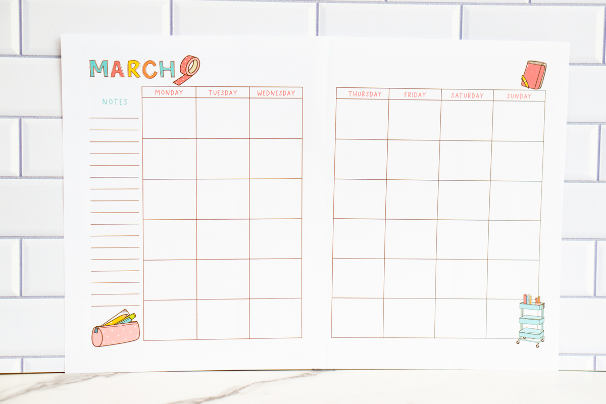 March craft-themed undated calendar page on a white subway while backdrop with a marble countertop.