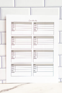 A photo of a printable page featuring six contact cards including a &ldquo;socials&rdquo; field in each box. The cards appear in soft gray and muted color accents, shown against a white subway-tile background.