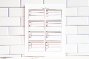 A photo of a printable page featuring six contact cards including a &ldquo;socials&rdquo; field in each box. The cards appear in soft gray and muted color accents, shown against a white subway-tile background.
