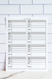 Printable contact list sheet with eight sections for name, phone numbers, email, and address, photographed against a white tile background.