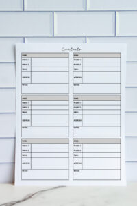 Printable contact list with four large entry sections including name, phones, email, address, and notes, shown upright against a white tile wall.