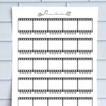 A printed movie tracker page displayed against a light blue tile wall. The sheet features horizontal film-strip frames with blank boxes for movie titles and star-rating rows under each frame.