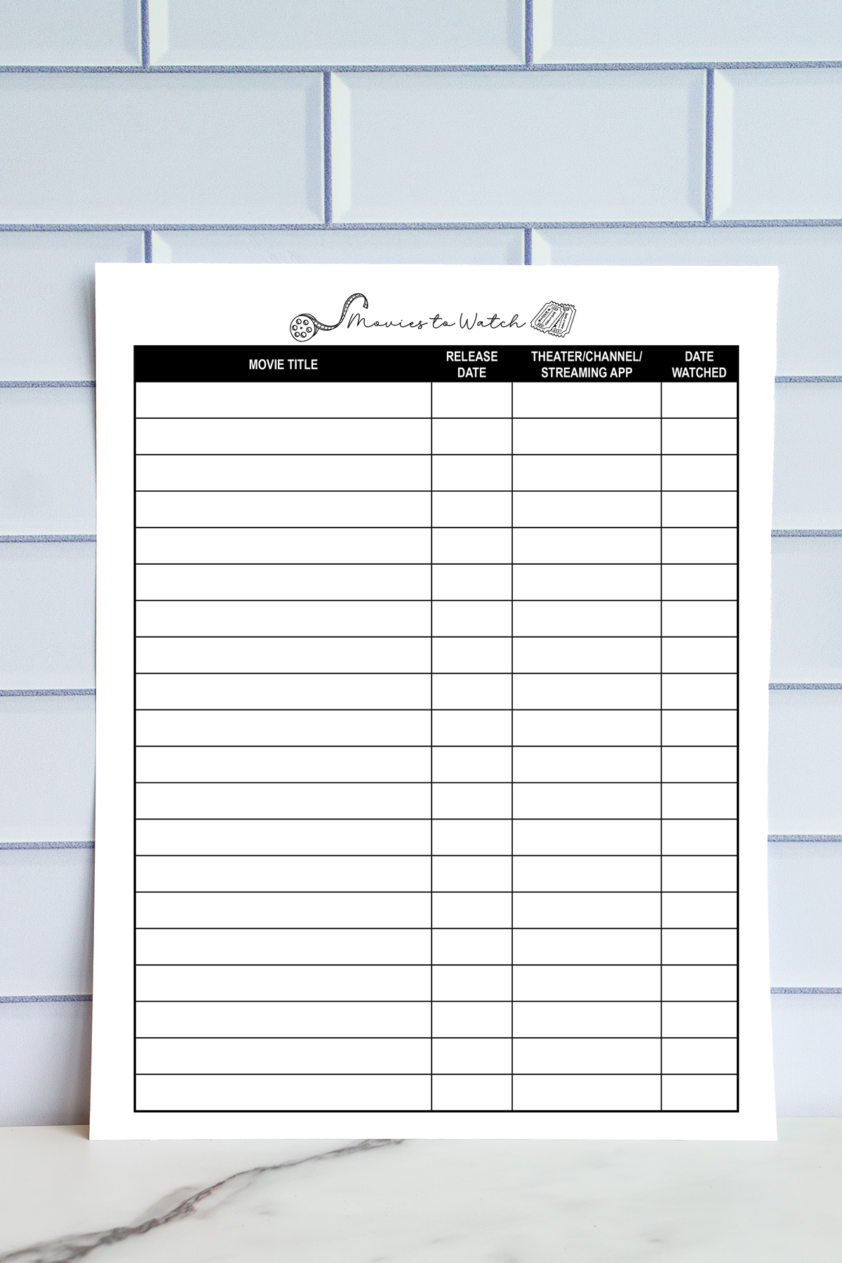 A printed &ldquo;Movies to Watch&rdquo; tracker page displayed upright. It features columns for movie title, release date, theater or streaming platform, and date watched.