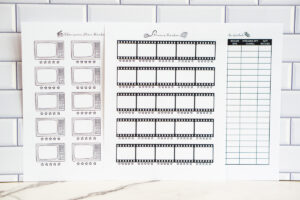 Three printed TV and movie tracker pages displayed side by side against a white subway tile background, including a television show tracker with retro TV icons, a movie tracker with film strip boxes, and a &ldquo;Movies to Watch&rdquo; list with organized columns.