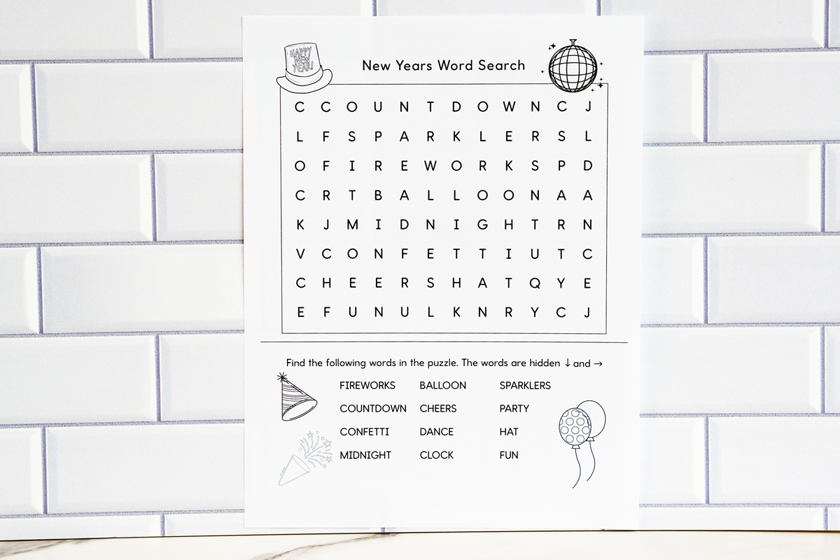 Alt text: The same simplified New Year’s word search printable displayed straight-on against a white subway tile background, featuring the grid and themed word list with small party icons.