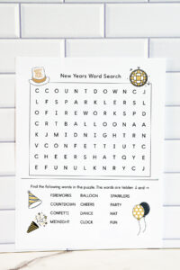 A simple New Year's word search printable displayed against a white subway tile background, featuring a beginner-level puzzle grid with large letters and a short themed word list illustrated with party icons.