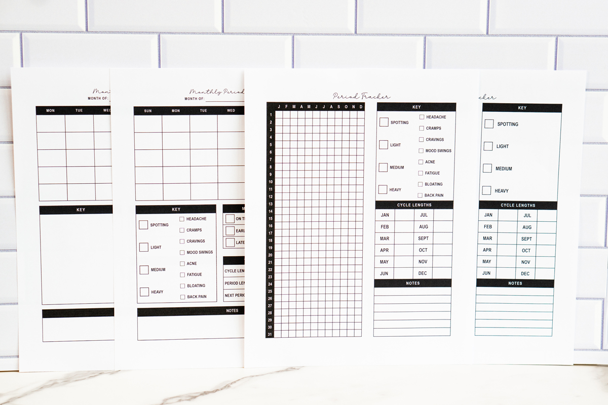 &ldquo;Four printable period tracker pages displayed side by side against a white subway tile background. The set includes two monthly trackers with blank calendars and symptom keys, and two yearly trackers with a 31-day grid, symptom checklists, cycle length charts, and notes sections.