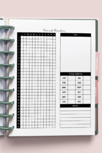 Yearly period tracker layout inside a disc-bound planner with a vertical grid for tracking flow levels, a blank symptom key, cycle length chart, and notes section, displayed against a soft pink background.