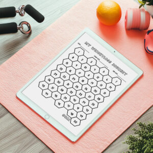 An iPad on a pink exercise mat showing a hexagon-style numbered weight loss tracker labeled MY WEIGHTLOSS JOURNEY, with dumbbells, a jump rope, and an orange resting nearby.