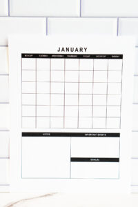 Vertical undated January monthly calendar page with grid layout and three planning boxes labeled Notes, Important Events, and Goals, displayed against a white subway tile backsplash.
