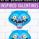 A Pinterest-style image with layered text reading &ldquo;FREE PRINTABLE KPOP DEMON HUNTERS INSPIRED VALENTINES.&rdquo; The text appears in white and black over purple bands. A small cartoon duck graphic is shown in the corner. Below the text, a single Derpy Valentine is centered on a white subway tile background, with a Valentine card visible on Derpy&rsquo;s tongue.