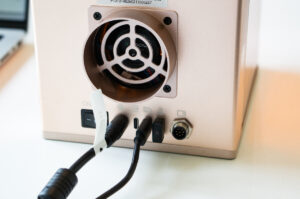 Power and USB cables connected to the rear ports of the xTool F2 laser engraver during setup.